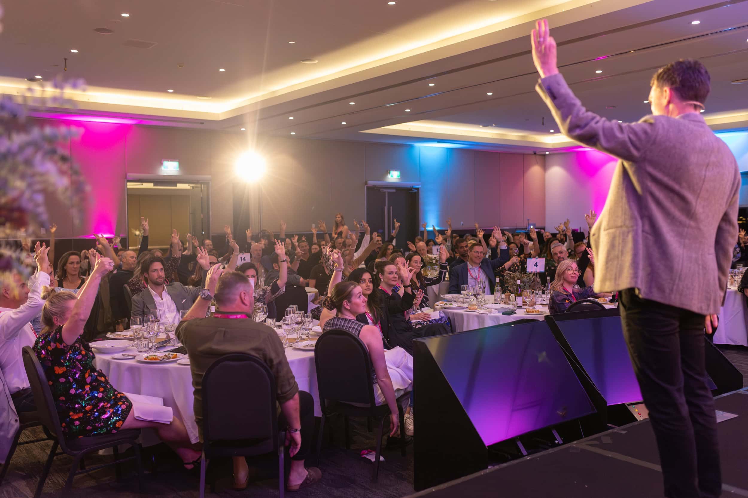 Andy Nunn speaking to an audience at a brightly lit corporate event