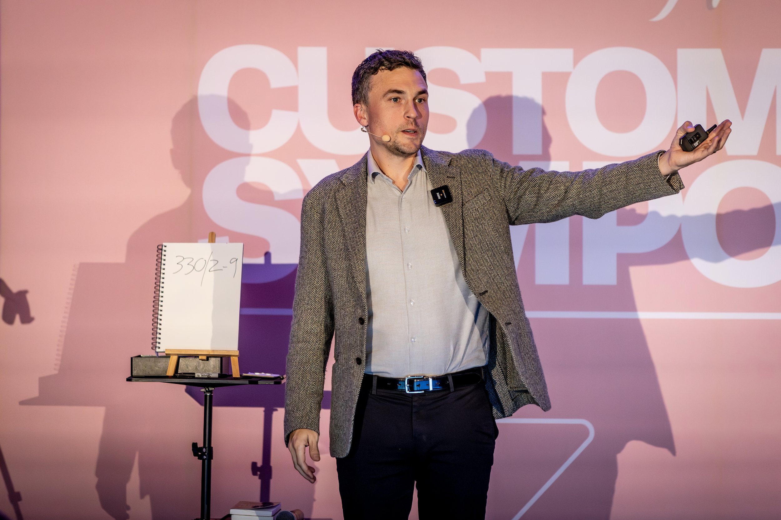 Andy Nunn pointing towards a presentation screen at a corporate event
