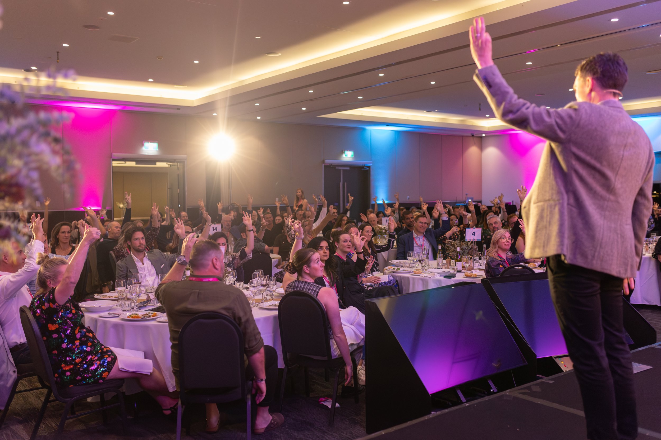 Andy Nunn speaking to an audience at a brightly lit corporate event