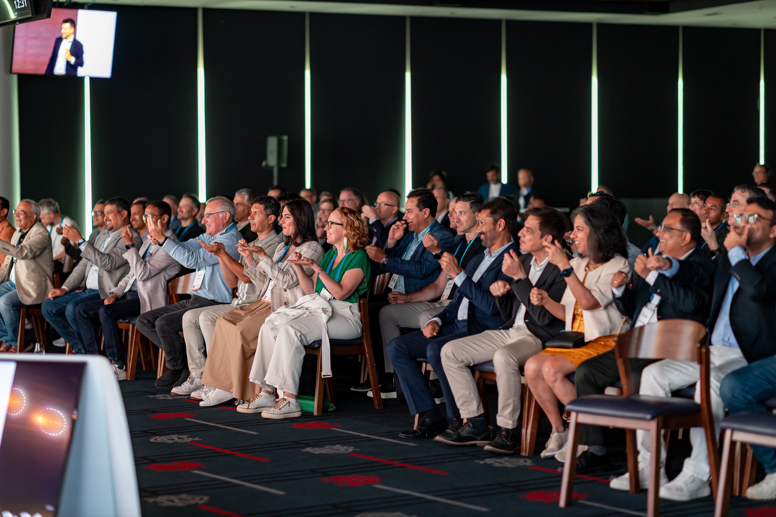 Corporate audience watching an Andy Nunn keynote from theatre seating