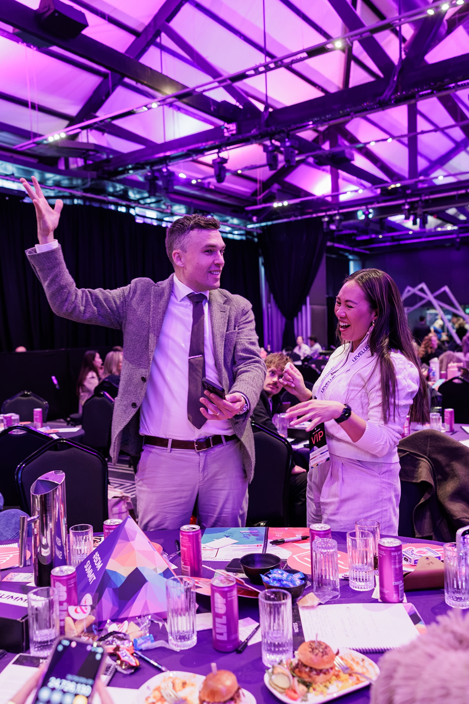 Andy Nunn entertaining a guest during a purple-lit corporate event