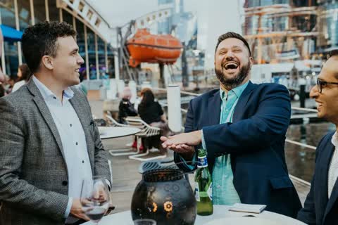 A corporate guest laughing during Andy Nunn's roving mentalism in Sydney