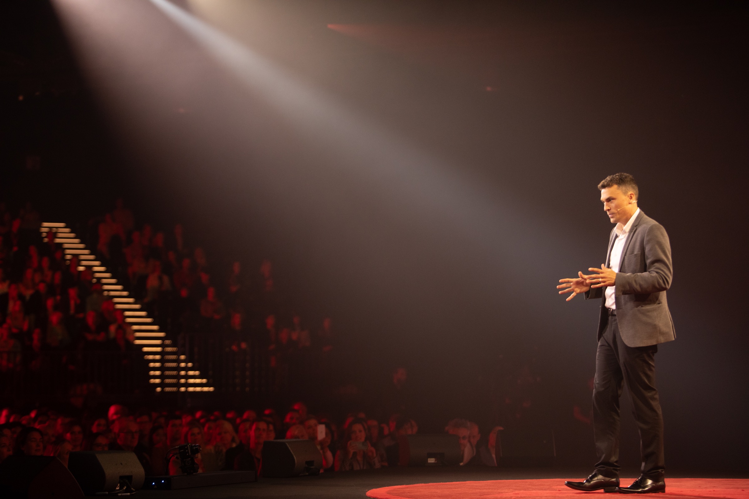 Andy Nunn presenting a keynote under stage lights in Melbourne