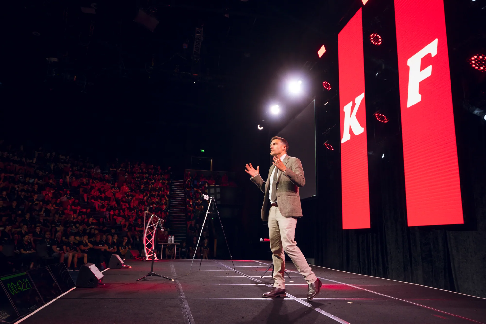 Andy Nunn leadership speaker with a large audience visible beside the stage