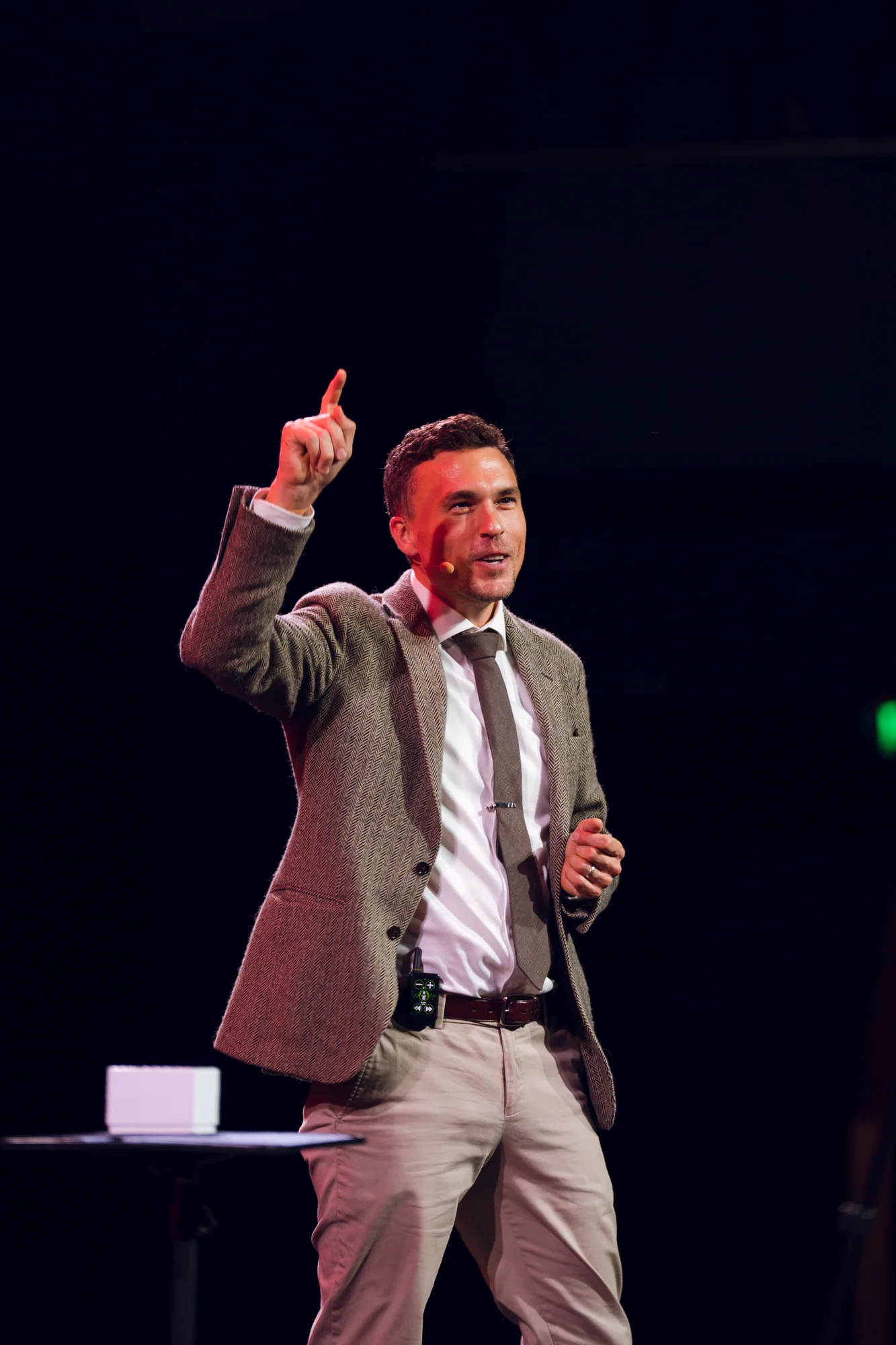 Andy Nunn raising his hand while speaking on a corporate stage