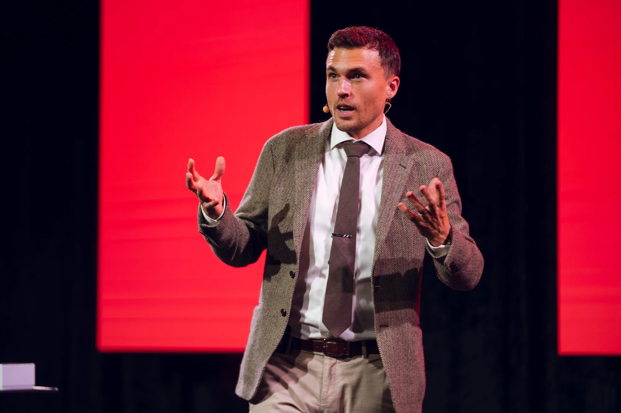 Andy Nunn presenting on a wide corporate stage as a motivational speaker