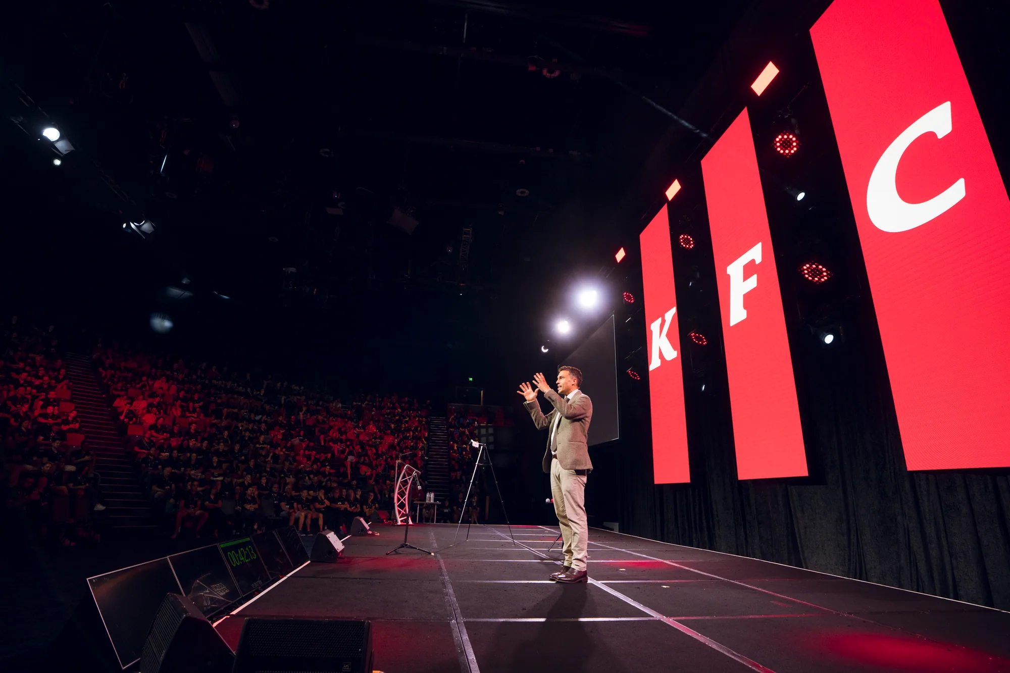 Andy Nunn speaking from the stage to a large corporate audience
