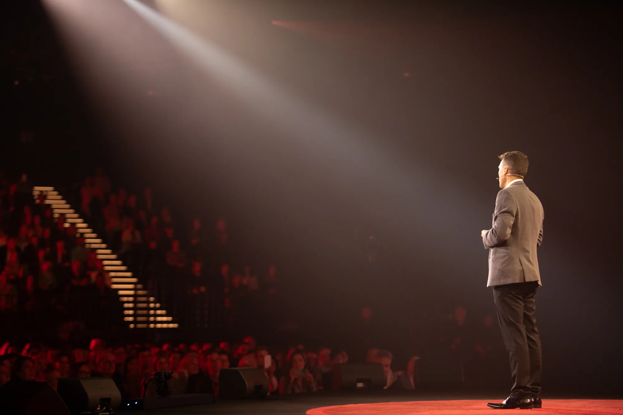 A theatre audience watching Andy Nunn from the side of the stage